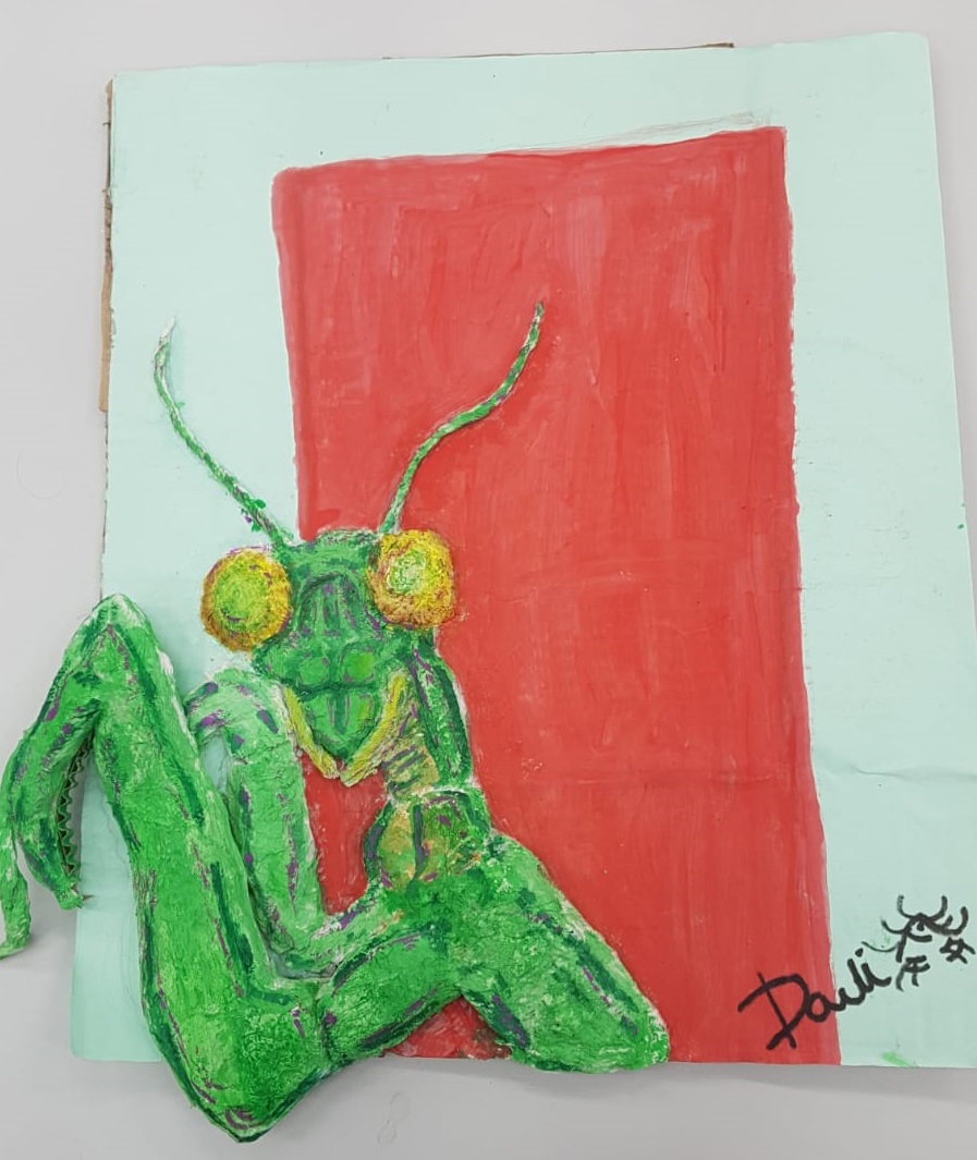 Louva-a-deus estilizado em verde vibrante com olhos grandes amarelos e laranja, sobre fundo vermelho com borda azul-claro.