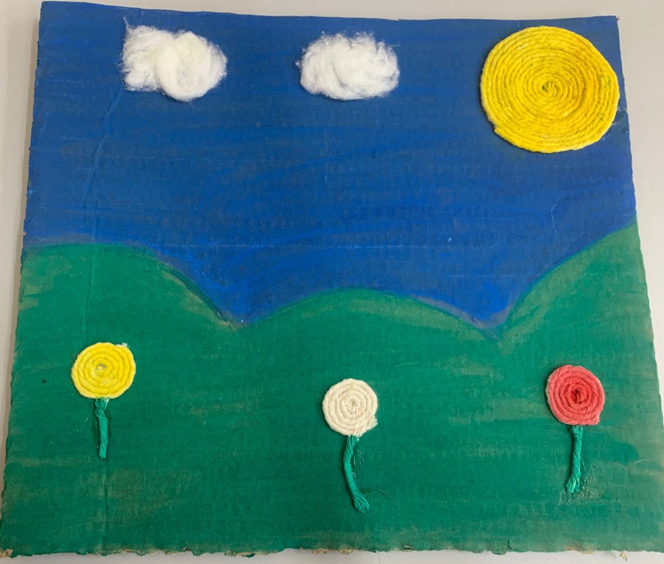 A obra é uma composição com flores, nuvens de algodão e um sol, transmitindo leveza, tranquilidade e alegria